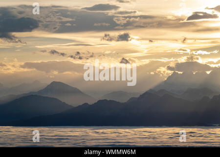 view of the Alps at sunrise, in the foreground Lake Geneva cloudy Stock Photo