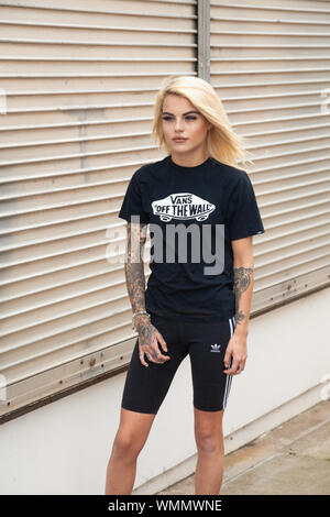 A young blond woman with tattoos wearing cycle shorts as a fashion item, Scotland. Stock Photo