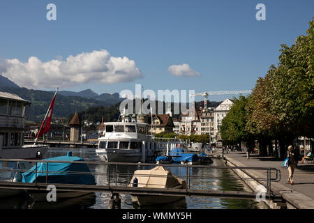 Boats on Lake Lucerne on a summer day in the city of Lucerne, Switzerland, looking toward the old town and the chapel bridge. Stock Photo