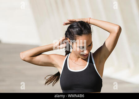 Young Hispanic female athlete in stylish sports bra and leggings looking  away while standing at stadium Stock Photo - Alamy