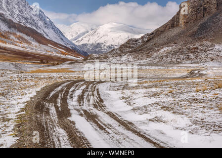 Picturesque Autumn Landscape With A Dirt Rocky Road Golden Larch Trees And Snowy Mountains Against A Blue Sky With Clouds Atay Russia Stock Photo Alamy