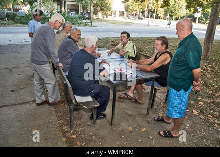 ZRENJANIN, SERBIA, SEPTEMBER 05,2019. A group of senior citizens mostly retirees having fun playing cards outdoors in the park. Stock Photo