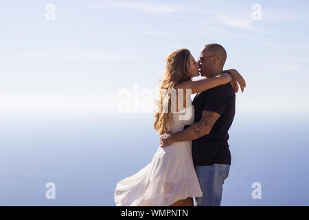 Couple hugging enjoying seascape on summer day Stock Photo