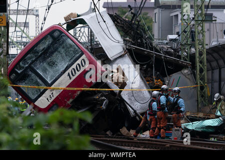 Fire brigade and policemen at the Kanagawa-Shinmachi station in Yokohama, Japan.A train collided with a truck that was stuck at the railroad crossing and at least 33 people were injured and one person died. Stock Photo