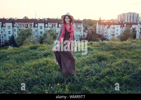 Beautiful young woman enjoying the sunset on top of a hill. Idea of rest and relaxation Stock Photo