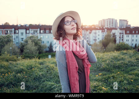 Beautiful young woman enjoying the sunset on top of a hill. Idea of rest and relaxation Stock Photo