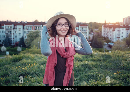 Beautiful young woman enjoying the sunset on top of a hill. Idea of rest and relaxation Stock Photo