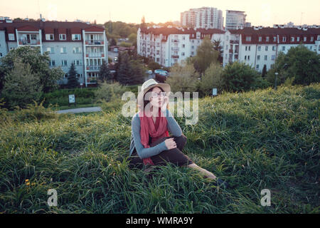 Beautiful young woman enjoying the sunset on top of a hill. Idea of rest and relaxation Stock Photo