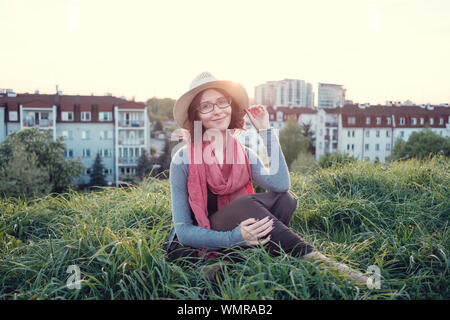 Beautiful young woman enjoying the sunset on top of a hill. Idea of rest and relaxation Stock Photo