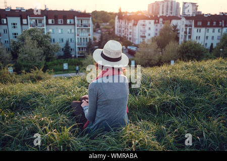 Beautiful young woman enjoying the sunset on top of a hill. Idea of rest and relaxation Stock Photo