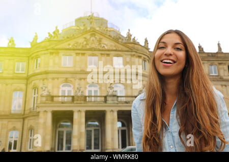Smiling young woman in front of Neues Schloss (New Palace) of Stuttgart, Germany Stock Photo