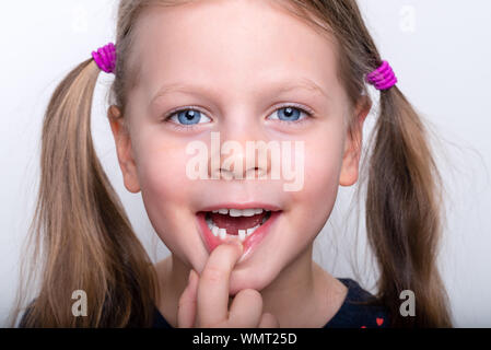 Child girl dropped the first milk tooth - preschooler girl with open mouth without milk tooth Stock Photo