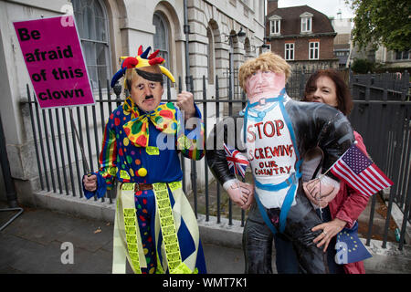 Anti Brexit protester dressed as a clown version of Boris Johnson with messages to Stop Brexit, Stop the Coup and Pro Democracy in Westminster on the day after Parliament voted to take control of Parliamentary proceedings and prior to a vote on a bill to prevent the UK leaving the EU without a deal at the end of October, on 4th September 2019 in London, England, United Kingdom. Yesterday Prime Minister Boris Johnson faced a showdown after he threatened rebel Conservative MPs who vote against him with deselection, and vowed to aim for a snap general election if MPs succeed in a bid to take cont Stock Photo