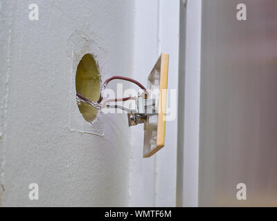 Old light switchers detached from a wall and electric wires Stock Photo