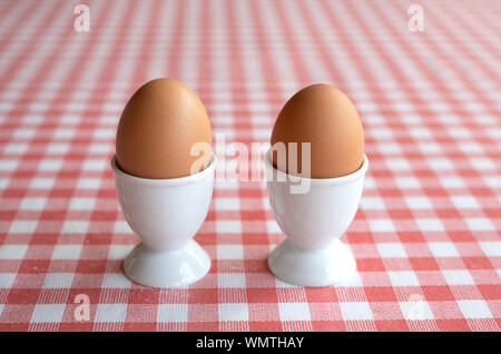 Two boiled eggs on a red and white background Stock Photo