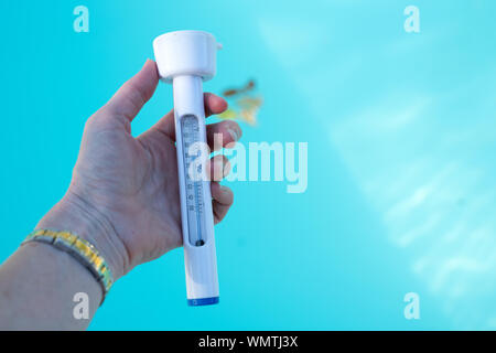 Reading a water thermometer in swimming pool, checking water temperature  Stock Photo - Alamy