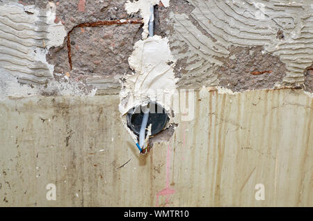 New electric installation in a wall for a socket outlet during reconstruction works in an apartment Stock Photo