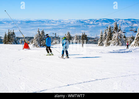 Kopaonik, Serbia - January 20, 2016: Ski resort panoramic view, ski slope, people skiing down the hill, mountains panorama Stock Photo