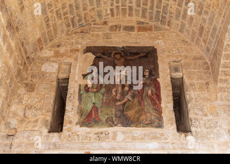 Italy, Apulia, Metropolitan City of Bari, Polignano a Mare. Mural of the Crucifixion painted on a stone wall. Stock Photo