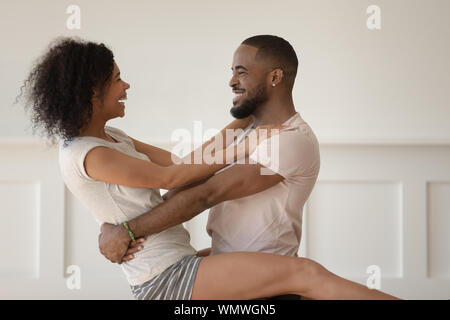 Happy african american man holding joyful smiling wife. Stock Photo