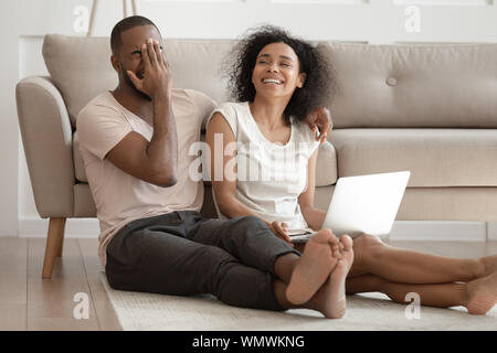 Happy african american family couple laughing at joke, having fun. Stock Photo
