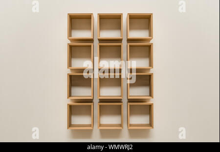slick wooden square book shelves on a claen beige background Stock Photo