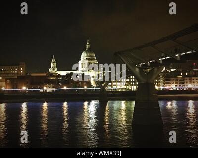 Millennium Bridge Over River Thames Leading Towards Illuminated St Paul Cathedral At Night
