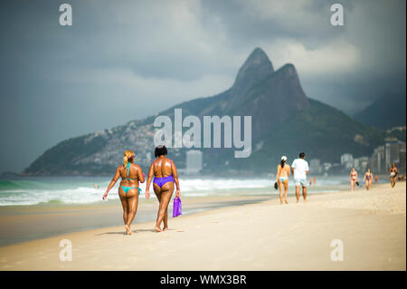 RIO DE JANEIRO - JANUARY 20, 2018: Beachgoers stroll along Ipanema Beach on a bright summer morning. Stock Photo