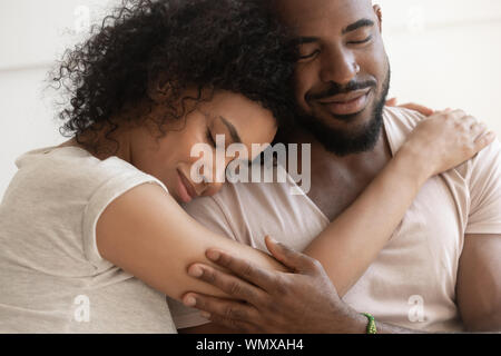 Close up african american woman lying on husbands shoulder. Stock Photo