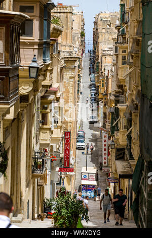 Malta, Valetta, Old Town, St. Ursula Street, narrow, steep street, with residential houses and the typical clad balconies, Stock Photo