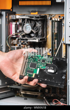 Closeup image of technician man hand changing the hard drive of pc computer . Maintenance and repair computer hardware service concept . Stock Photo