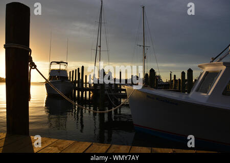 The sun sets over the harbor at Silver Lake on Ocracoke Island on the Outer Banks of North Carolina. Stock Photo
