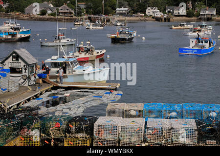 Lobster fishing boats in Bass Harbor with lobster traps on the dock of village of Bernard in foreground.Tremont.Maine.USA Stock Photo