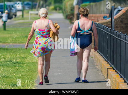 A couple of women walking home after spending a day on a beach in Summer in the UK. Stock Photo