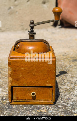 Rustic wooden vintage coffee grinder Single manual square shaped coffee grinder with little open drawer and metal handle Stock Photo