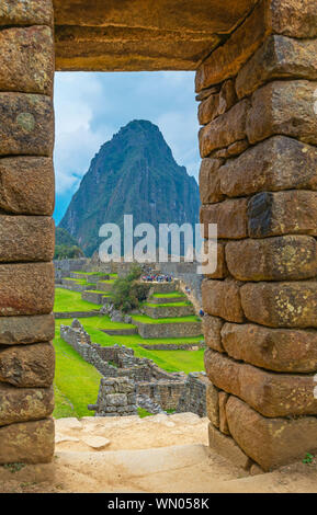 Inca architecture entrance door in the Machu Picchu ruin and the Huayna Picchu mountain in the background, Cusco, Peru. Unsharp door, sharp background. Stock Photo