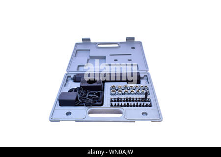 Closeup of hand screwdriver with electric charging and screwdrivers heads of different size in gray toolbox isolated on white background. Stock Photo