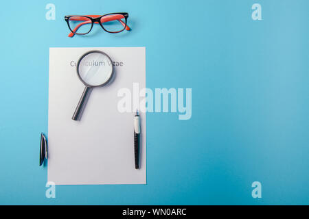 Curriculum vitae written on an blank white paper on blue background Stock Photo