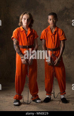 Boys in prisoner jumpsuits and handcuffs Stock Photo - Alamy