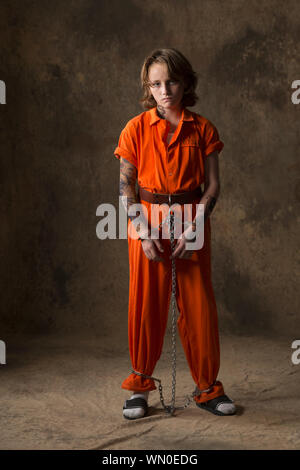 Boy in prisoner jumpsuit and handcuffs Stock Photo - Alamy