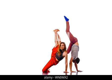 Modern style beautiful dancers working out. Young man doing handstand Stock Photo