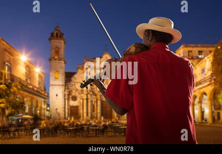 Senior man playing violin at night in Plaza de la Catedral, Havana, Cuba Stock Photo
