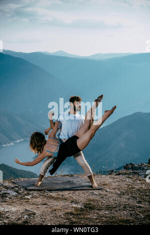 Two athletic young dancers making a performance at mountain peak Stock Photo