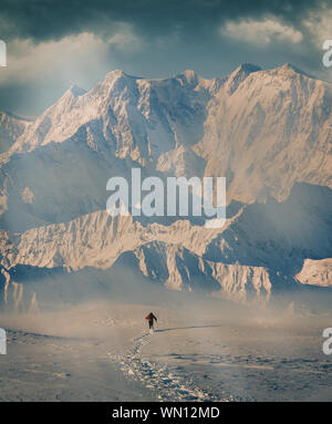 Man hiking through snow by mountain in Alpe Devero, Italy