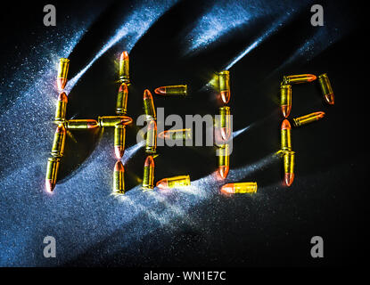 The word 'Help' is spelled out in 9mm bullets with dramatic side light and colors with mental health concept Stock Photo