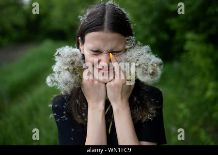 Teenage girl with her eyes closed holding dandelions Stock Photo