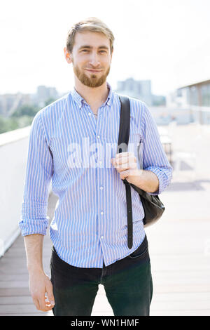 Bearded man wearing striped shirt and backpack Stock Photo