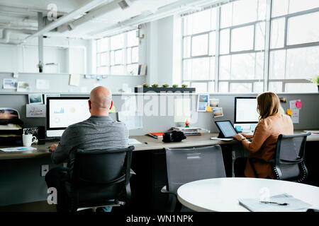Workers using computers in office Stock Photo