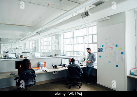 Workers using computers in office Stock Photo