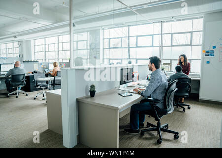 Workers using computers in office Stock Photo